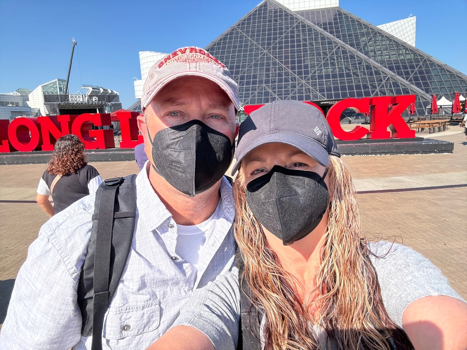 Deux personnes portant des masques devant le Rock and Roll Hall of Fame.