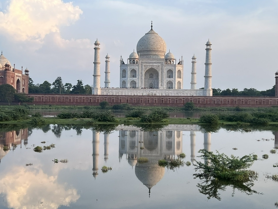 Le Taj Mahal se reflétant dans l'eau avec une atmosphère sereine.