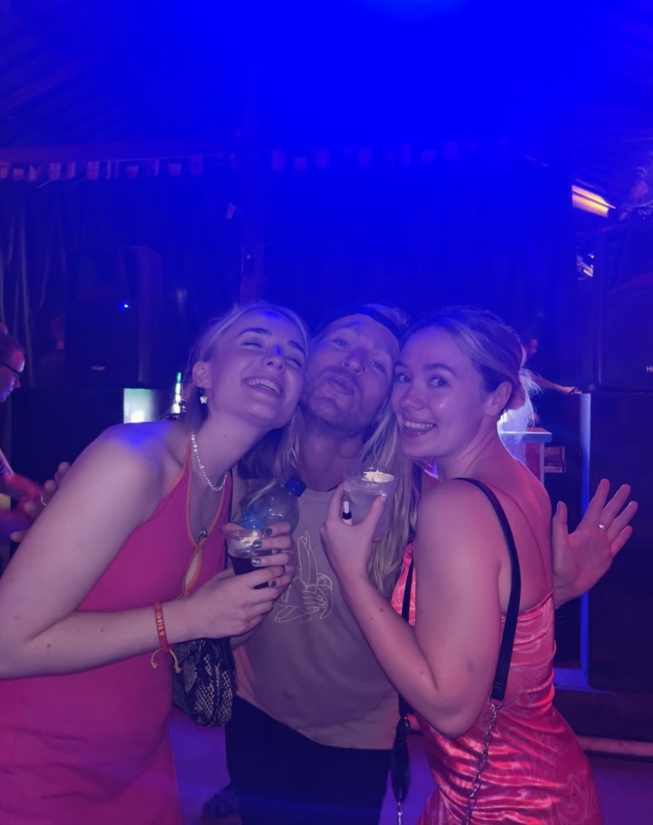 Groupe d'amis souriants qui posent dans un environnement faiblement éclairé.