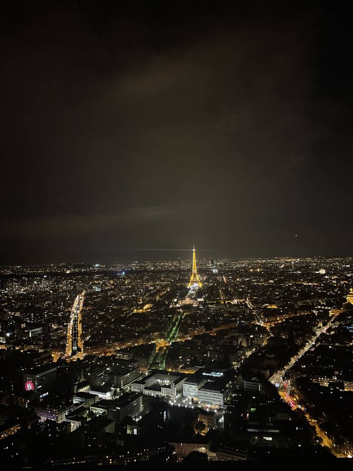 Vue nocturne d'une ville avec la tour Eiffel.