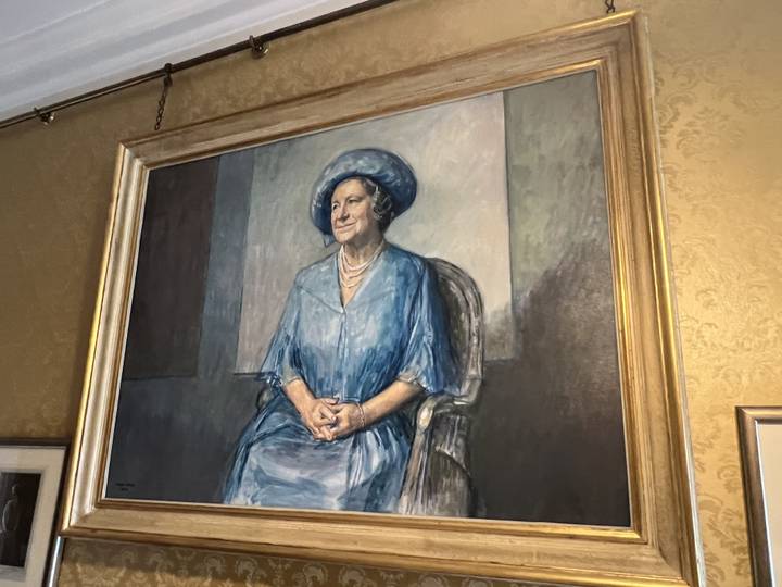 Portrait d'une dame en robe bleue dans un cadre orné.