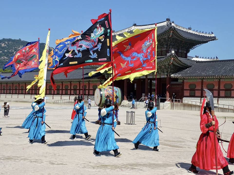 Cérémonie traditionnelle de la garde coréenne avec des drapeaux colorés.