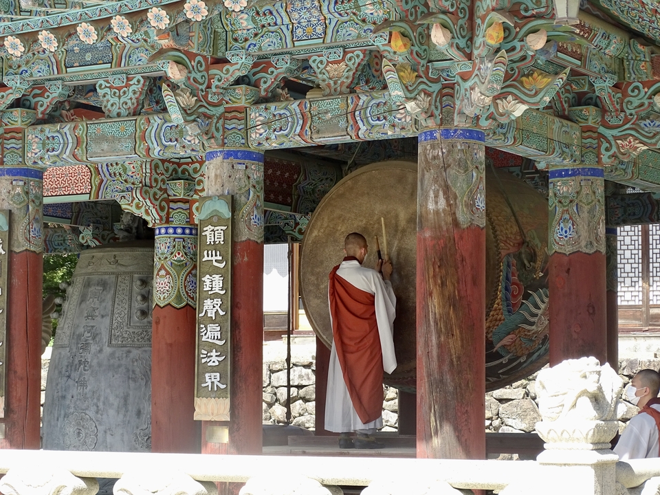 Moine dans un temple frappant un grand tambour.