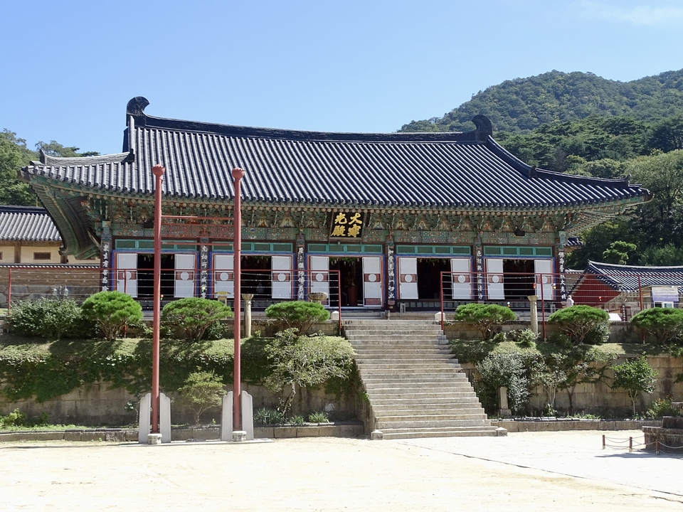 Bâtiment traditionnel de temple coréen dans une zone forestière.