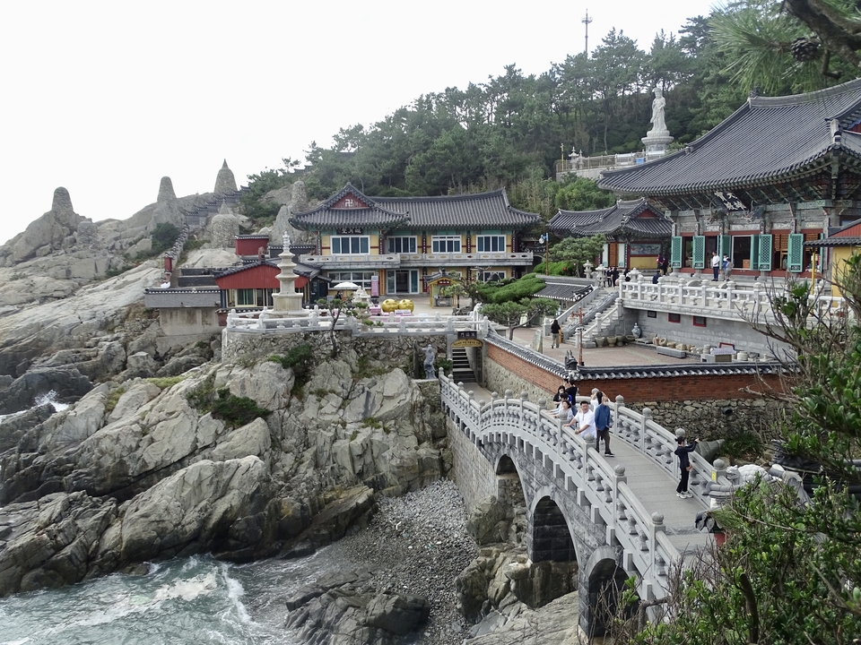 Temple sur falaise avec architecture coréenne traditionnelle sur un rivage rocheux.