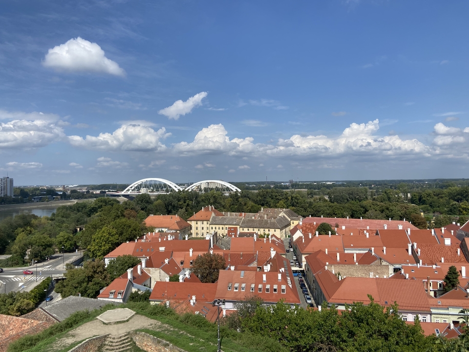 Luftaufnahme einer Stadt mit roten Dächern und einem Fluss.