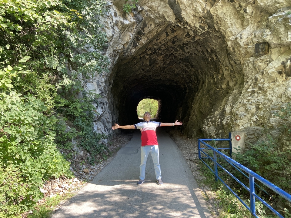 Person, die vor einem felsigen Tunneleingang steht.