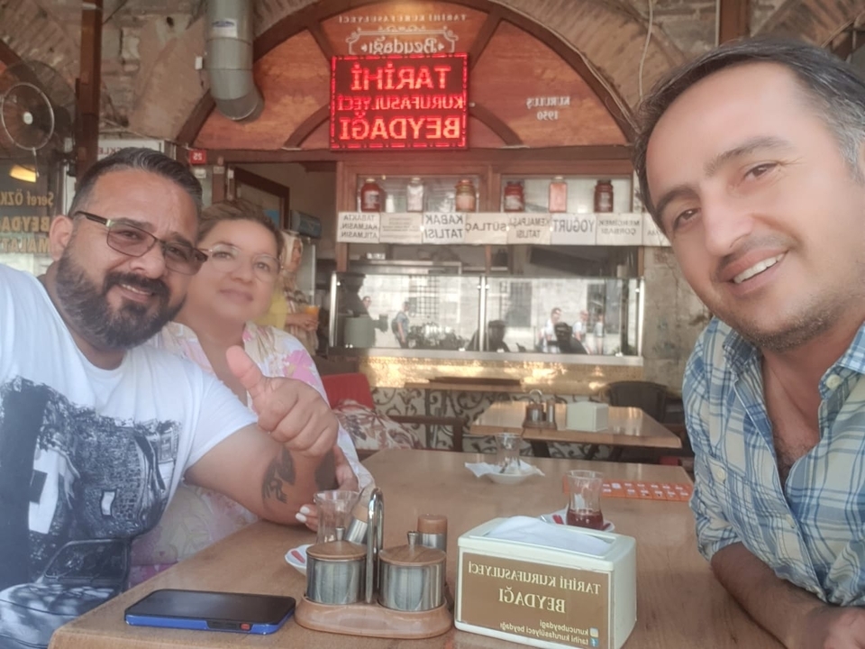 Trois personnes savourant des boissons dans un café local.