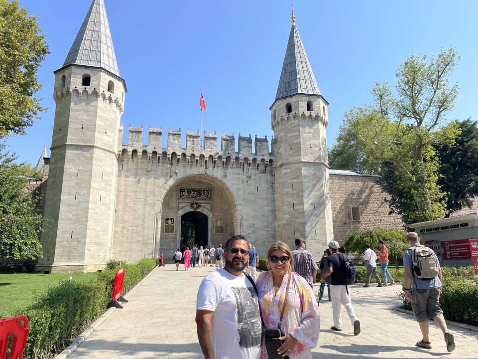 Couple posant devant un bâtiment historique.