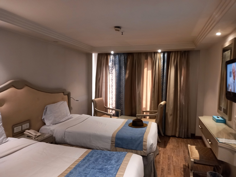 Intérieur d'une chambre d'hôtel avec lits jumeaux et une fenêtre.