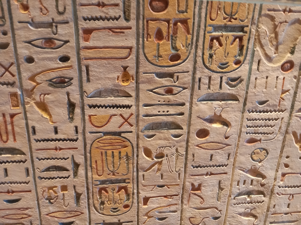 Gros plan d'hiéroglyphes égyptiens antiques gravés dans la pierre.