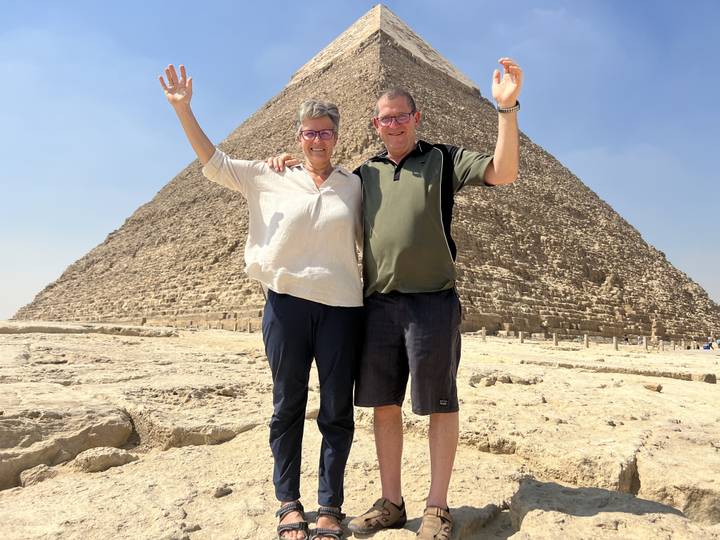 Couple posant devant une pyramide.