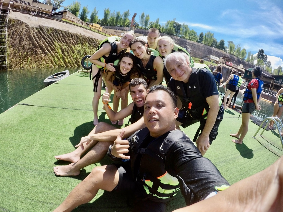 Groupe de personnes portant des gilets de sauvetage posant sur un quai.