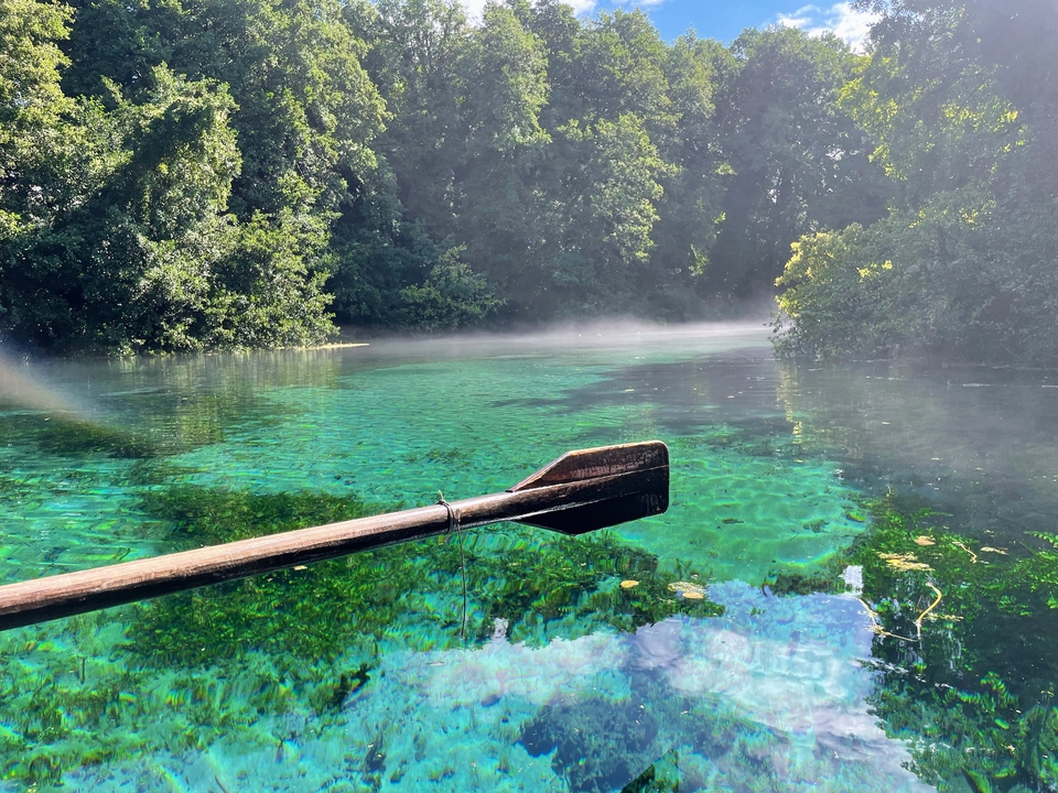 Pagayer sur une eau claire avec un arrière-plan brumeux.