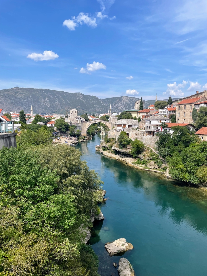 Pont de pierre emblématique enjambant une rivière avec ville historique.