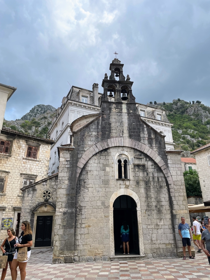 Façade d'une vieille église en pierre parmi les collines.