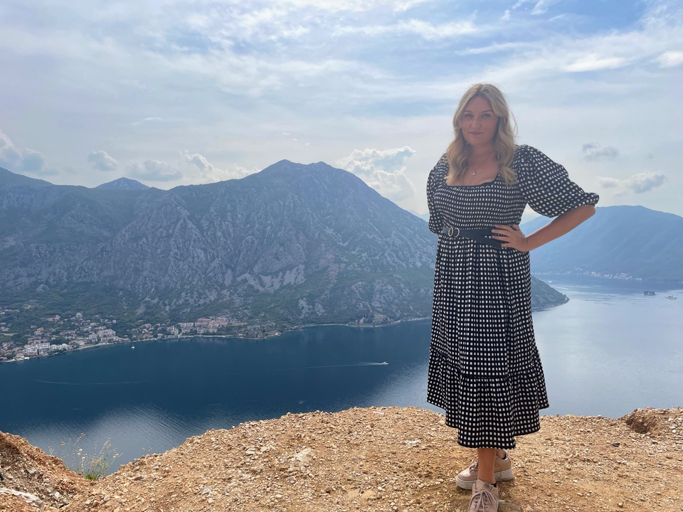 Femme posant avec une vue magnifique sur la montagne et la mer.