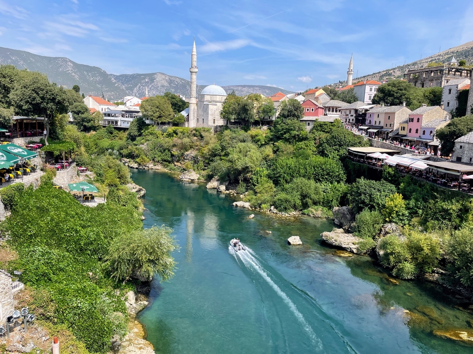 Rivière avec des bateaux, une mosquée et des bâtiments colorés.
