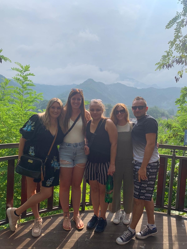 Groupe de personnes posant devant un paysage de montagne.