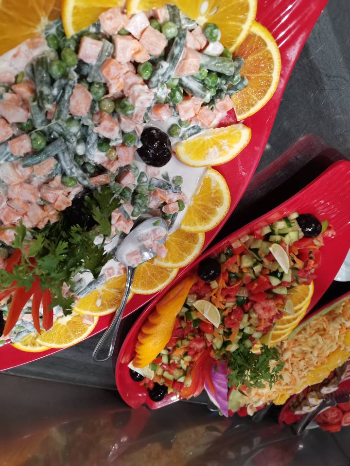 Assiettes de diverses salades colorées aux oranges.