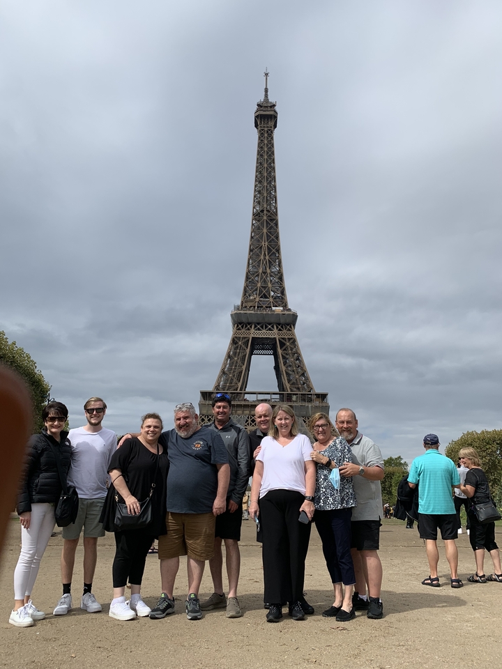 Groupe de personnes posant devant la Tour Eiffel.