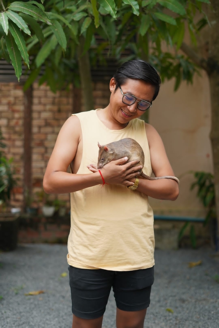 Personne tenant un rat.