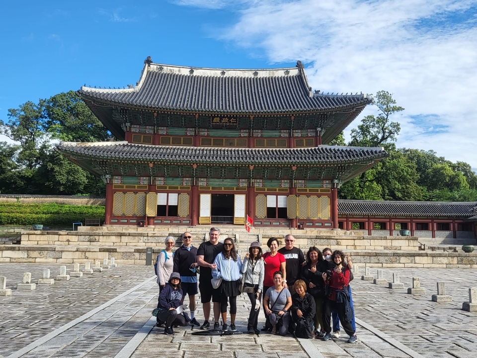 Un groupe de personnes debout devant un bâtiment traditionnel coréen