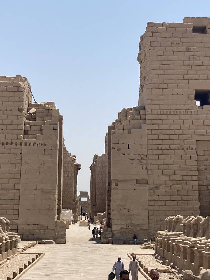 "Ruines anciennes avec plusieurs personnes qui marchent."