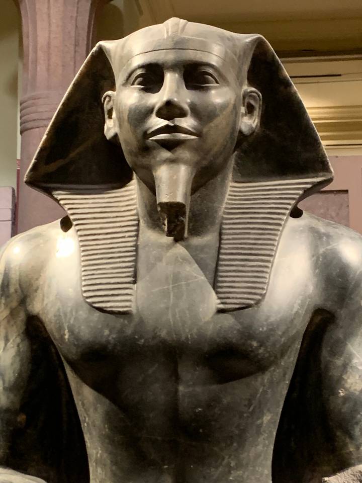 Statue égyptienne antique exposée dans un musée.