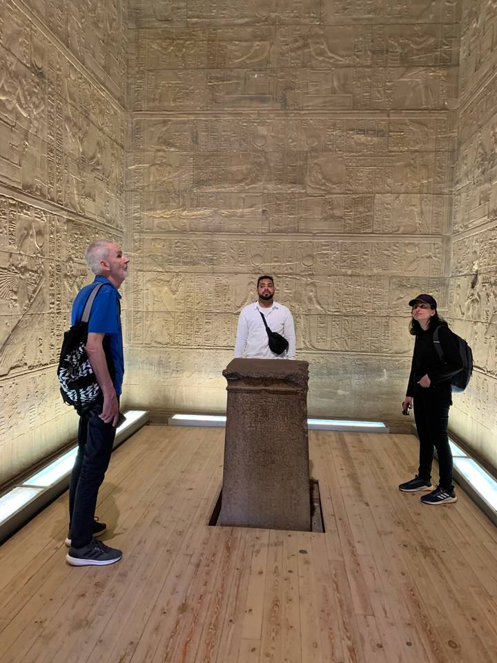 Des touristes à l'intérieur d'un temple avec des sculptures anciennes.