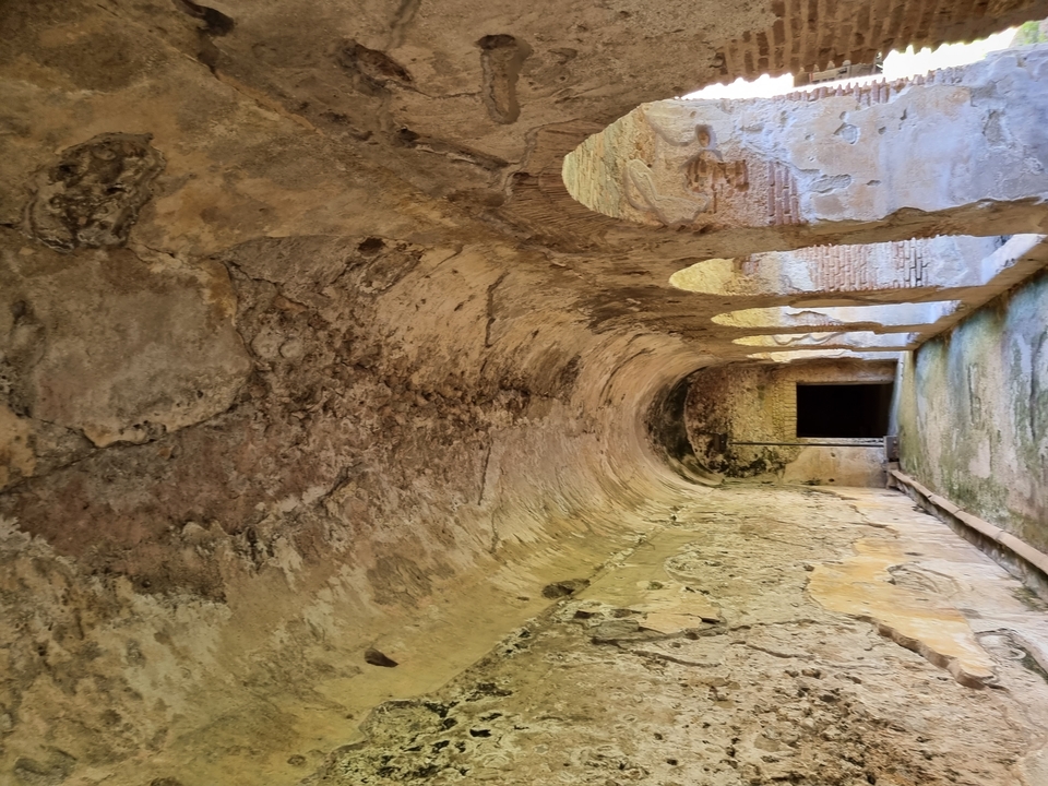 Ruines souterraines historiques avec arcades dans un site archéologique.