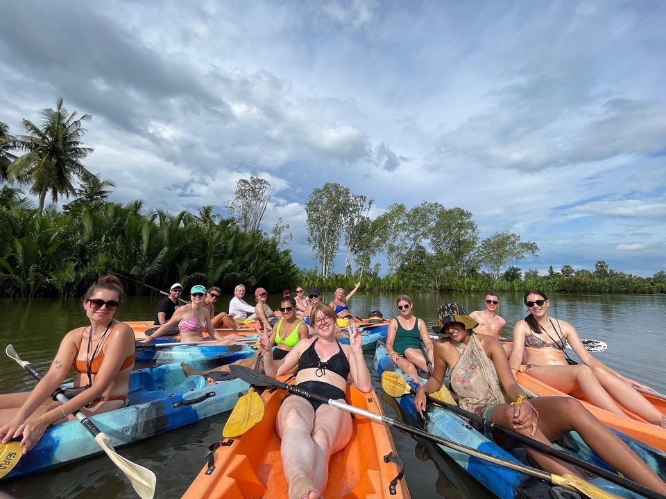 Groupe de personnes faisant du kayak sur une rivière entourée de verdure.