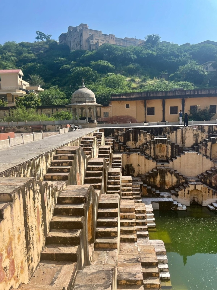 Réservoir d'eau à gradins avec des personnes en arrière-plan.