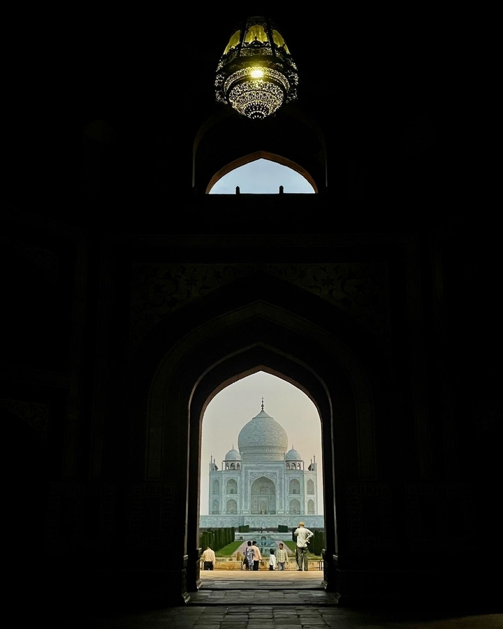 Silhouette du Taj Mahal vue à travers une arche.