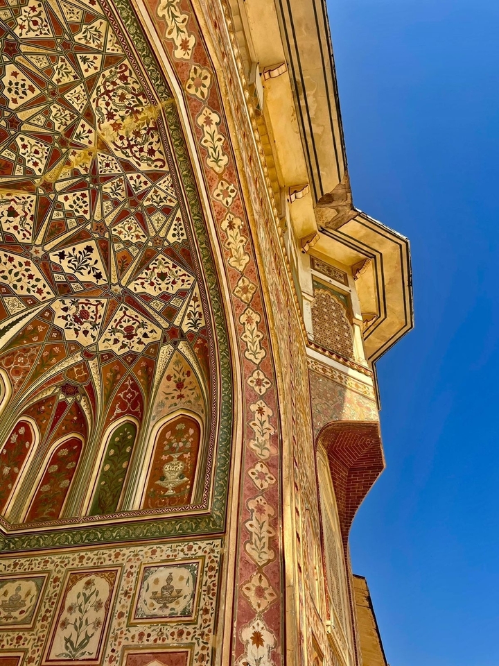 Vue détaillée d'un angle de bâtiment richement décoré sur fond de ciel bleu.