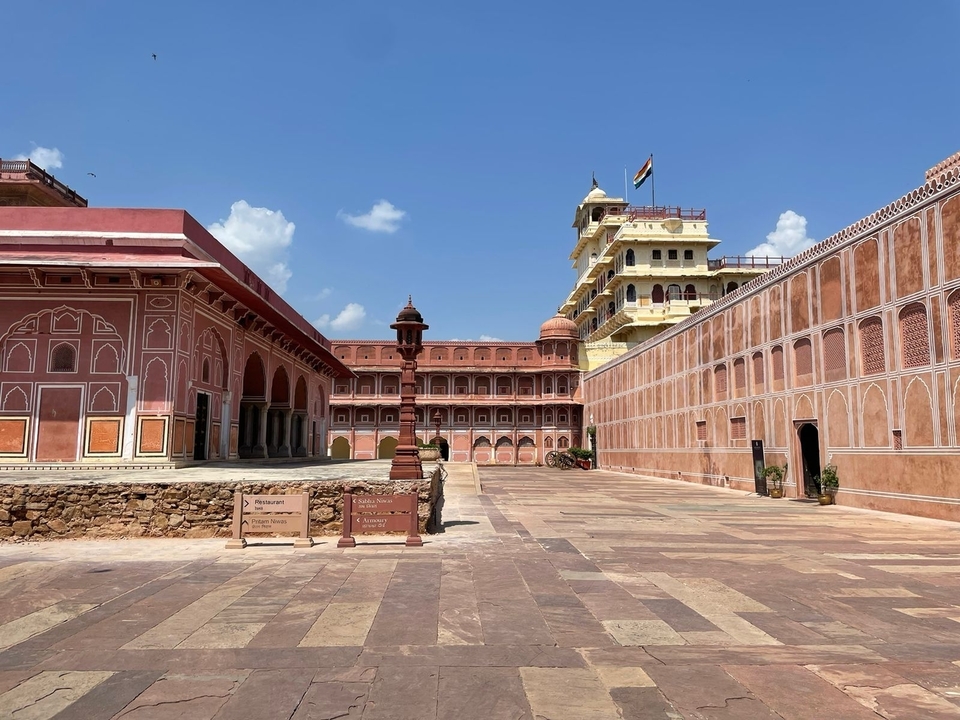 Une cour architecturale historique avec des bâtiments ornés et un ciel dégagé.