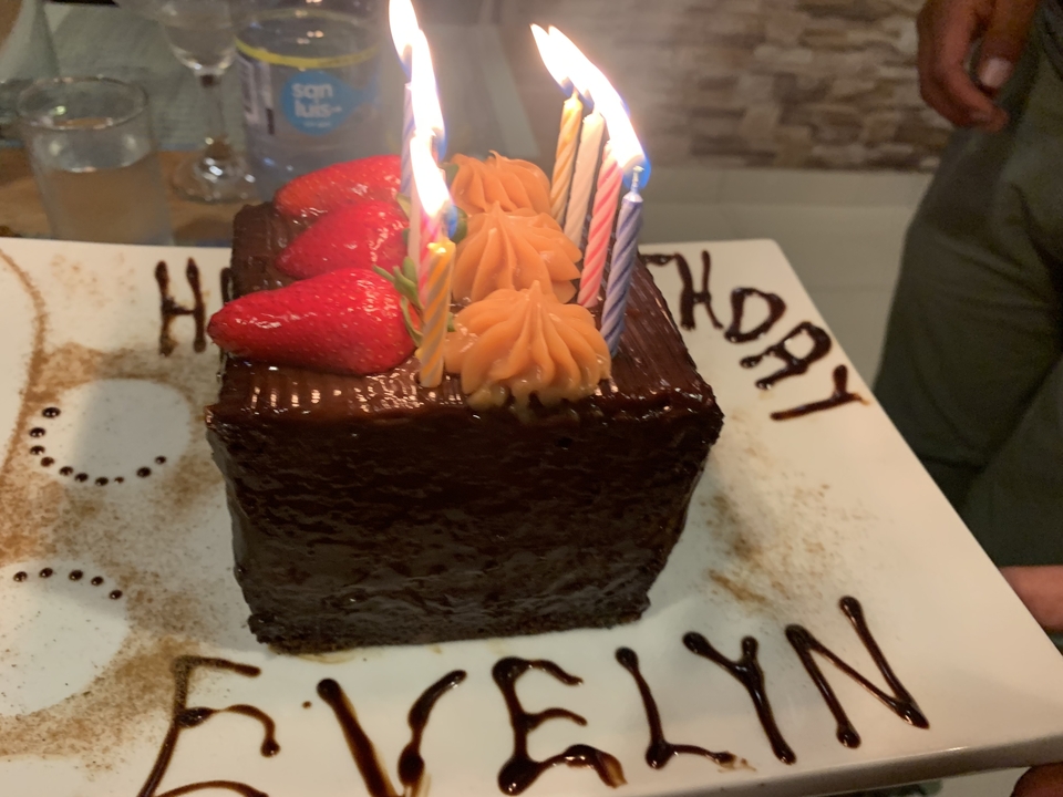 Un gâteau au chocolat avec des bougies et des fraises sur le dessus.