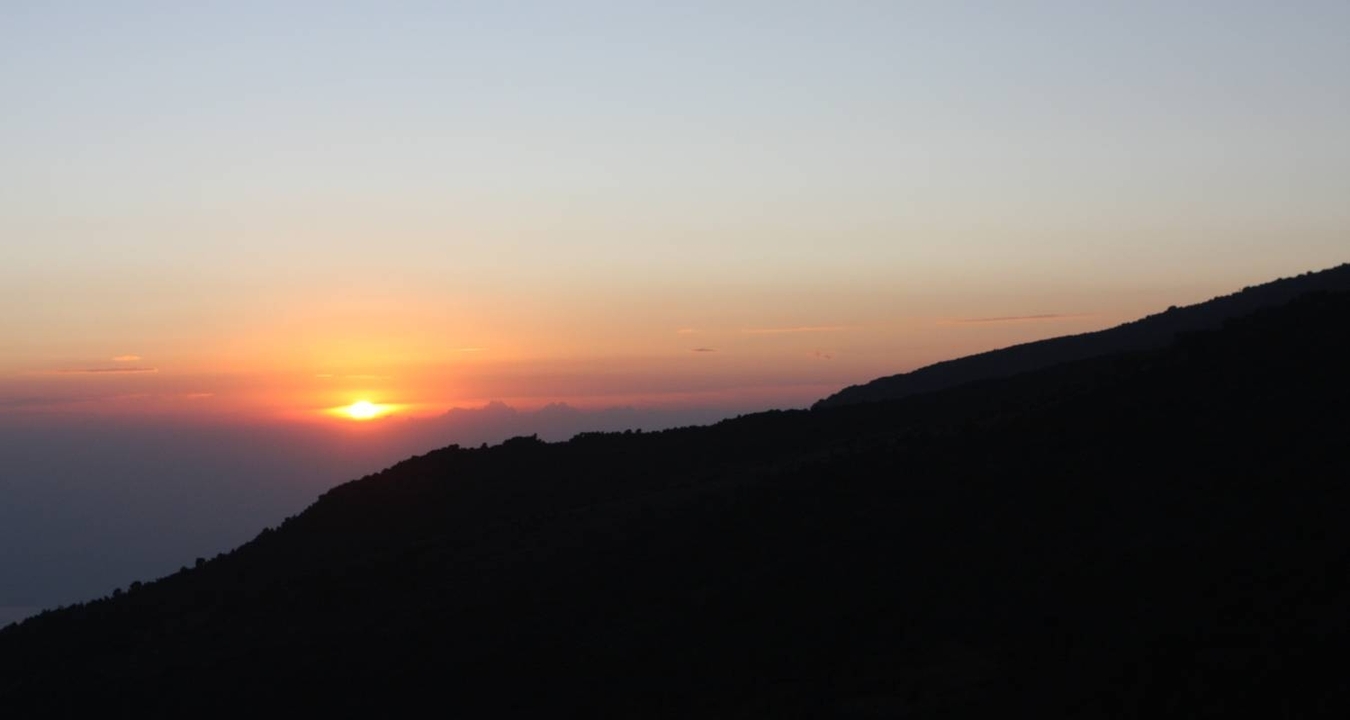 Vue du coucher de soleil sur les montagnes en silhouette.