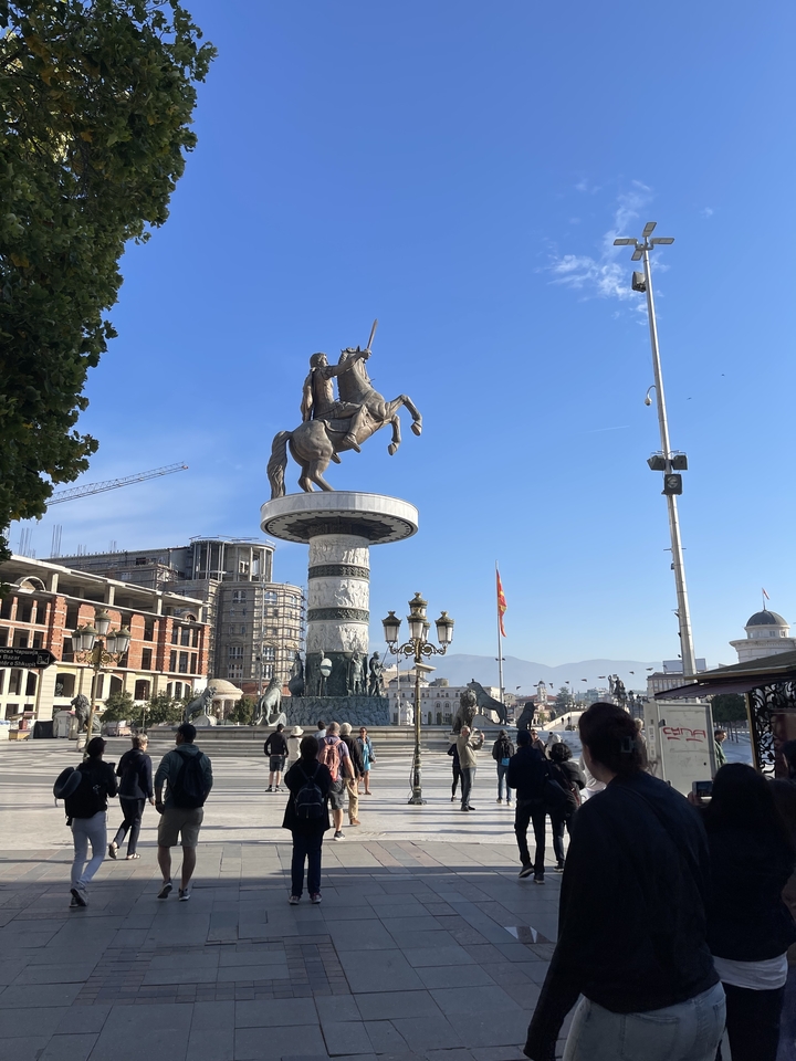 Statue d'un cavalier sur une place de ville avec des gens autour.