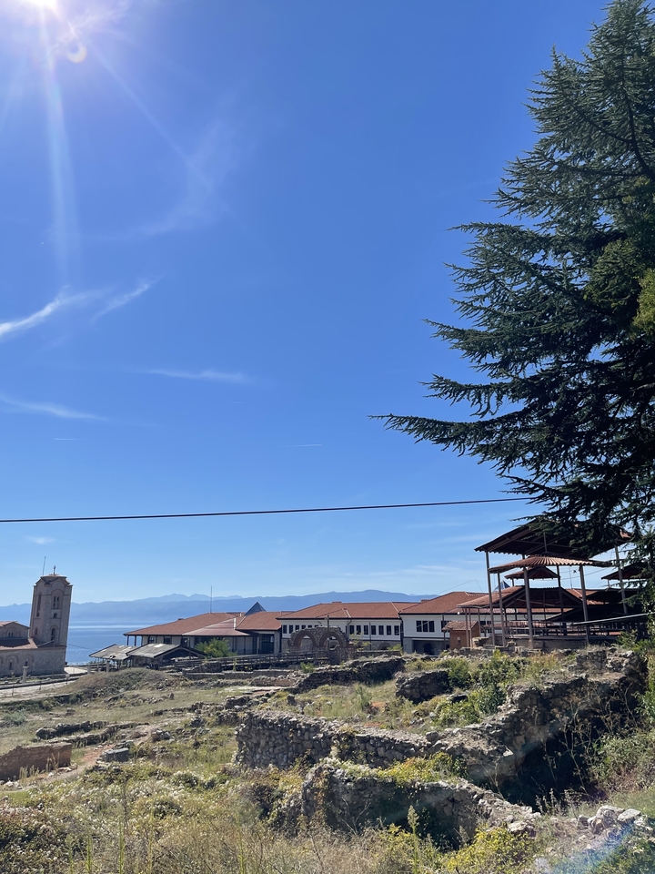 Une vue des toits avec un ciel bleu dégagé et des montagnes au loin.