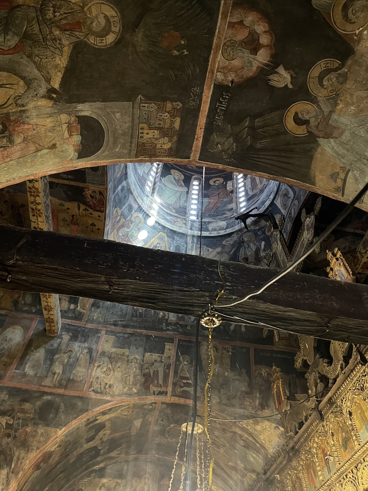 Intérieur d'une église avec des fresques et un plafond en coupole.