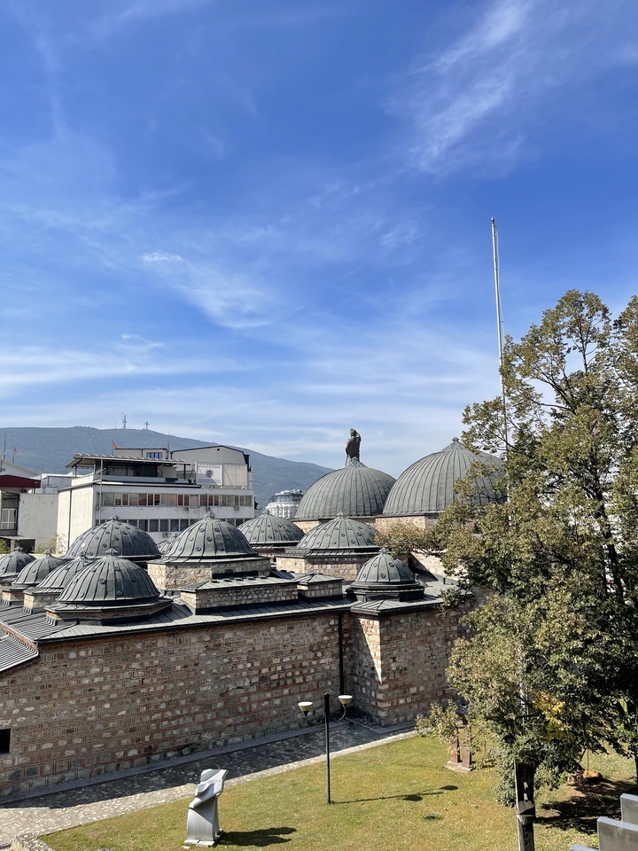 Une vue des toits avec des collines et un paysage urbain en arrière-plan.