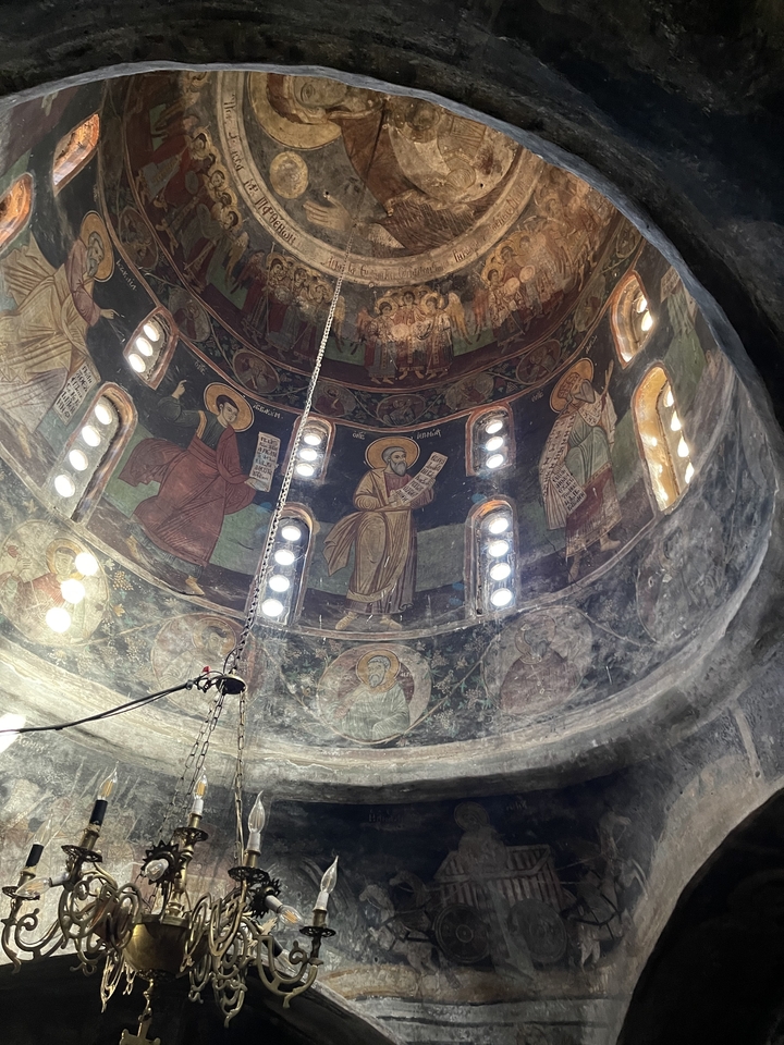 Intérieur d'une église richement décorée avec des fresques.