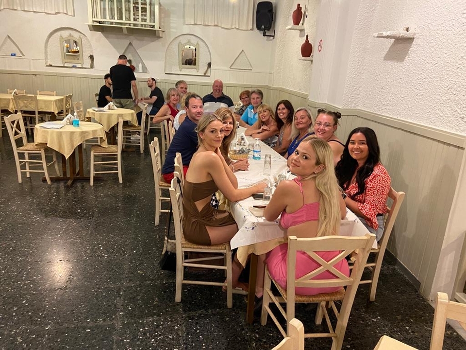 Group of people sitting around a dining table in a restaurant.