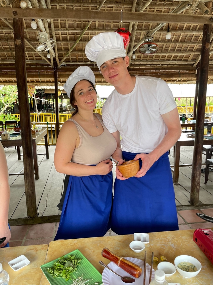 Deux personnes souriantes qui prennent la pose dans un cadre de restaurant rustique.