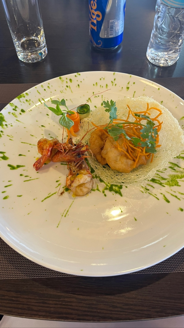 Plat dressé exquis avec crevettes grillées et garnitures.