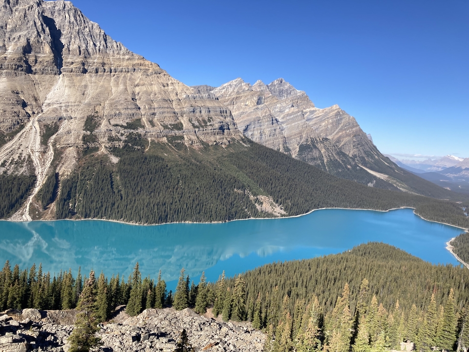 Vue large d'un lac turquoise entouré de montagnes.