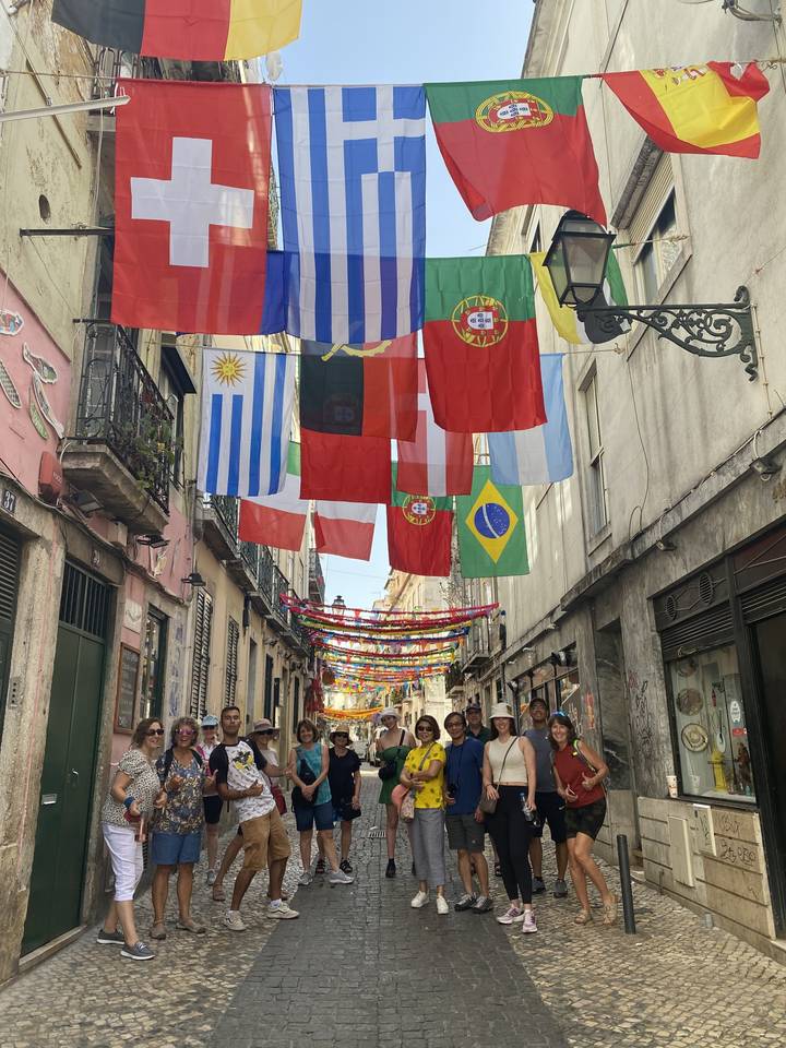 Translation from English to French:
"Rue avec drapeaux internationaux et groupe de personnes"
Alternative translation:
"Rue ornée de drapeaux internationaux avec un groupe de personnes"