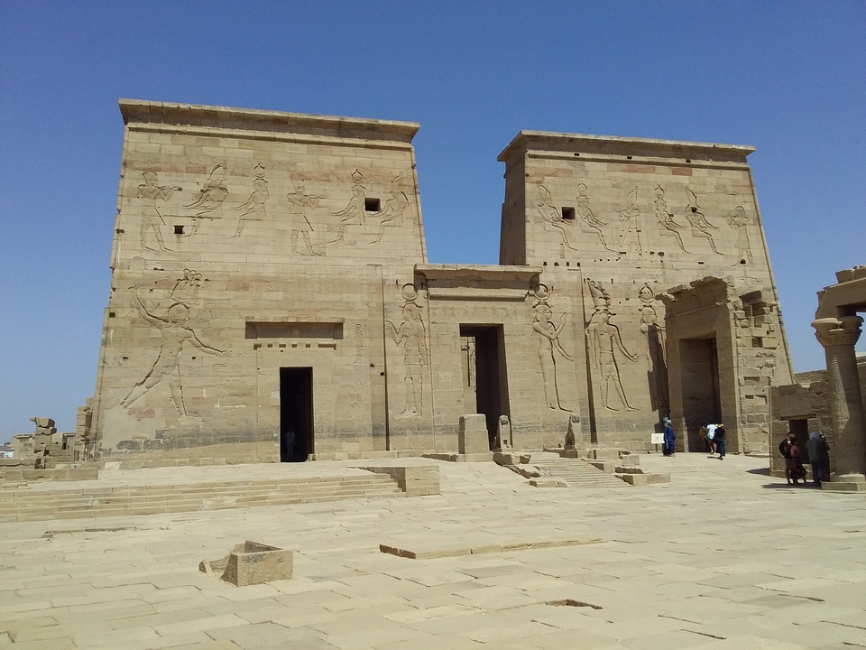 Façade d'un temple ancien avec des figures représentées sur les murs.