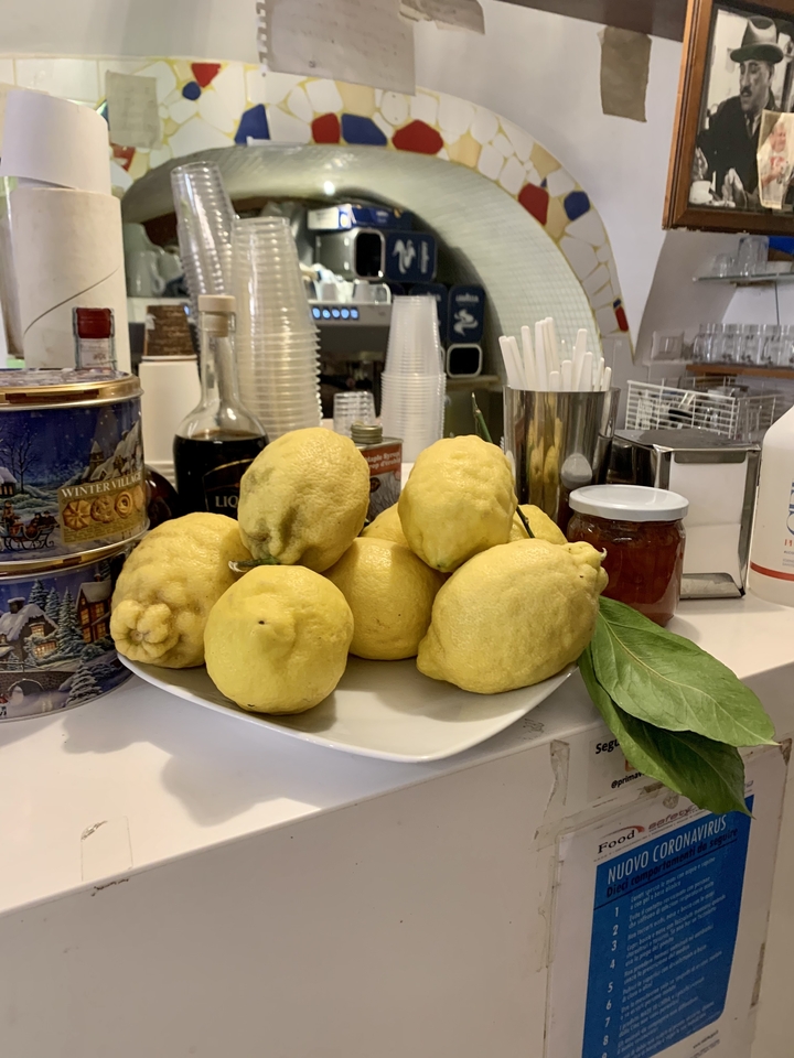 Une assiette de citrons frais sur un comptoir avec divers ustensiles de cuisine.